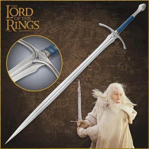 May include: A silver sword with a blue handle, featured in a promotional image for "The Lord of the Rings." The sword has a cross-shaped hilt and a long, pointed blade. A close-up shows the handle's intricate design. The image includes the film's logo.