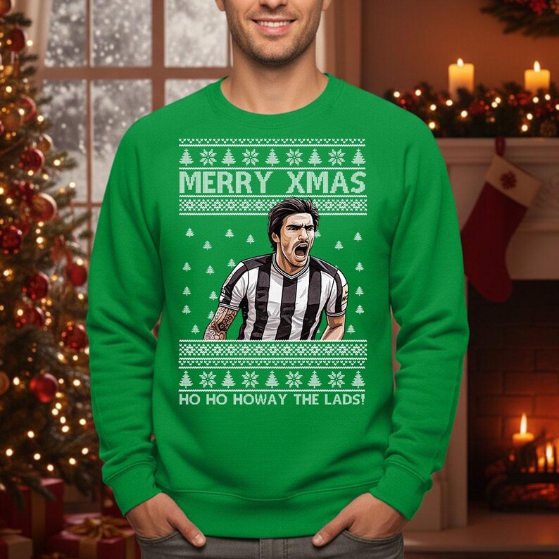 May include: Green Christmas sweater with the text "MERRY XMAS" and "HO HO HOWAY THE LADS!". The sweater features a graphic of a soccer player in a black and white striped jersey. The sweater has a festive design with Christmas trees.