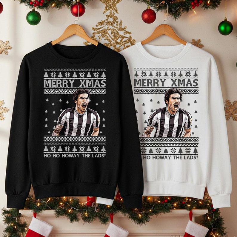 May include: Black and white sweatshirts with a festive design. Each sweatshirt features a graphic of a person and the text "MERRY XMAS" and "HO HO HOWAY THE LADS!". The sweatshirts are displayed on wooden hangers.