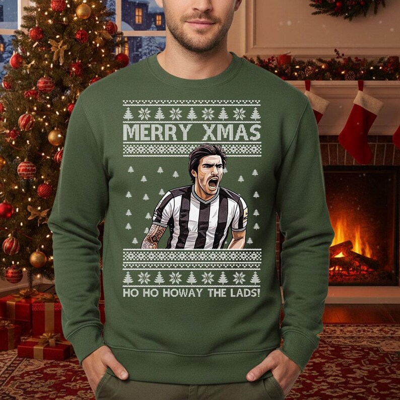 May include: Green Christmas sweater with the text "MERRY XMAS" and "HO HO HOWAY THE LADS!". The sweater features a graphic of a soccer player in a black and white striped jersey. The sweater has a festive design with snowflakes and Christmas trees.