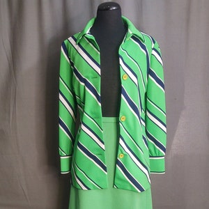 May include: A green and white striped blazer with a matching green skirt. The blazer has a collar and long sleeves. The skirt is knee-length and has a straight silhouette.