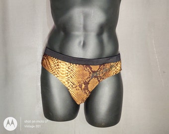 May include: A pair of brown and black patterned swimming trunks with a black waistband. The pattern resembles a snake skin.