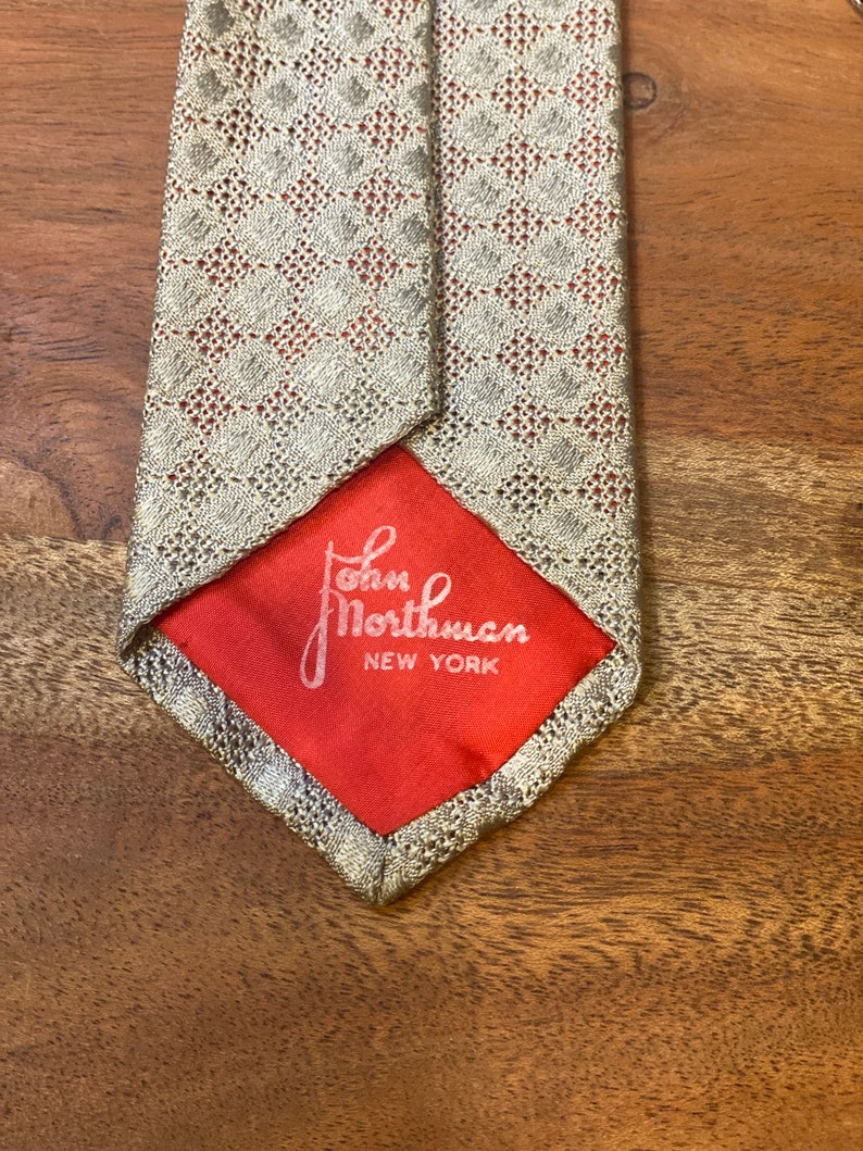 Back tip of Vintage John Northman New York Tie Silver / Gray mesh silk knit tie over coral color silk backing Hand tailored loomed in Italy