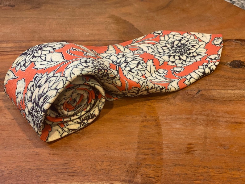 Front  and right side and rolled up view of vintage silk Chrysanthemum Floral Print in white  over orange Vintage 5 fold scarf with cream backing or lining of the tie