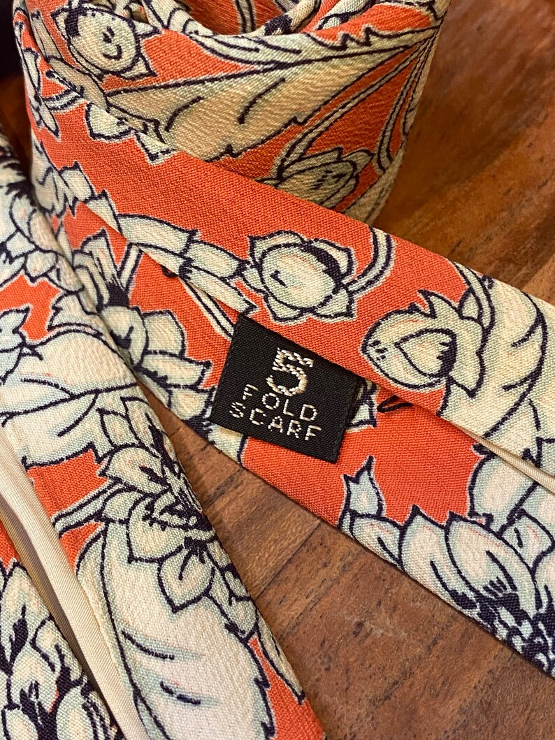 Back view and closeup of tag showing 5 fold scarf of vintage silk Chrysanthemum Floral Print in white  over orange  with cream backing or lining