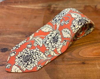 Cravatta in crepe di seta vintage anni '40 con stampa floreale a crisantemo in crema su arancione con contorno nero e riflessi blu-grigi