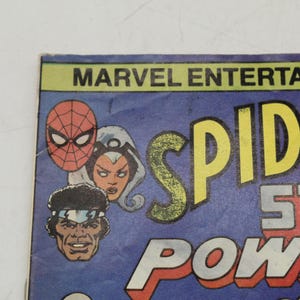 May include: Comic book cover featuring Spider-Man, Storm, and a third character. The title "Spider-Man" is in large yellow letters, with "Storm" and "Power" in red and white. The Marvel Entertainment logo is at the top.