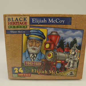 May include: A cardboard box for a 24-piece puzzle featuring Elijah McCoy, a portrait of him, and a steam train. The box has the text "Black Heritage Series" and "Elijah McCoy" with the years 1843-1929.