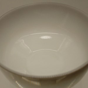 May include: A white ceramic bowl with a smooth, glossy finish. The bowl is empty and appears to be new.