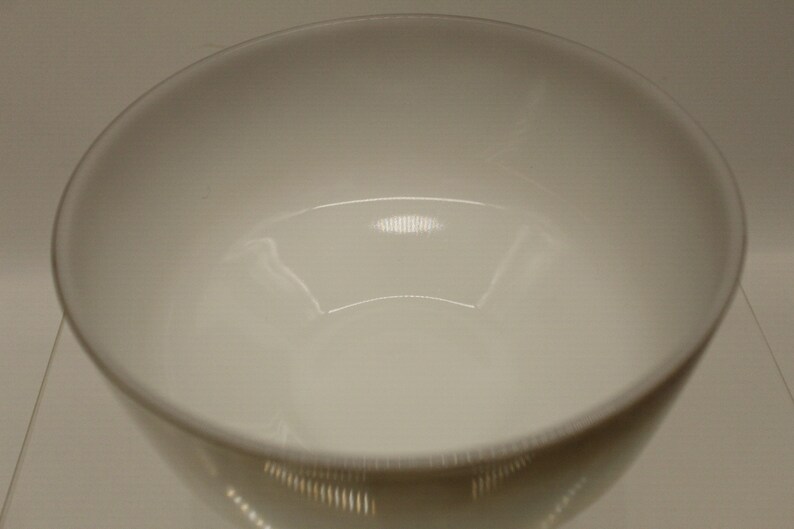 May include: A white ceramic bowl with a smooth, glossy finish. The bowl is empty and appears to be new.
