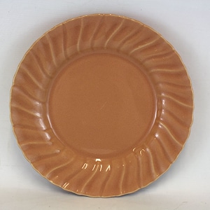 May include: A brown ceramic dinner plate with a wavy, fluted edge.