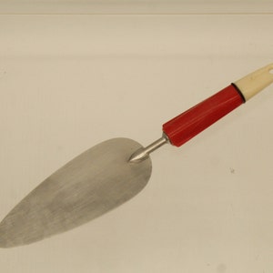 May include: A red and white handled cake server with a silver metal blade.