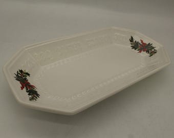 May include: White ceramic serving dish with a scalloped edge and a raised design. The dish has a festive holly and berry design on each end.