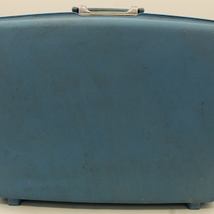 May include: A vintage blue hard-sided suitcase with a silver handle.