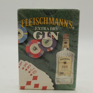 May include: A green box of Fleischmann's Extra Dry Gin playing cards. The box features a bottle of gin, poker chips, and a hand of diamonds. The text "Fleischmann's Extra Dry Gin" is displayed prominently.