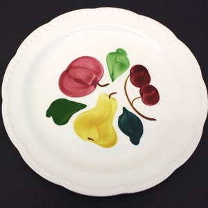 A white Stetson plate from the 1940s. Scalloped edge. Hand-painted with a red apple, yellow pear, two red cherries and three green leaves. A few utensil marks.