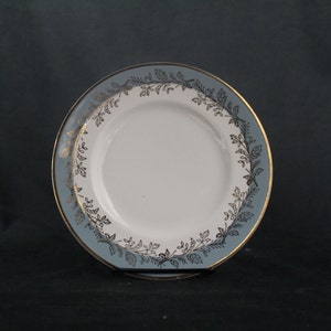 May include: A blue and white ceramic plate with a gold rim and a black floral design.