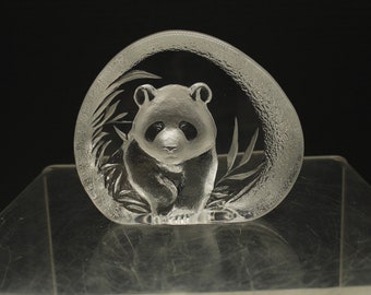 May include: A clear glass paperweight with a frosted design of a panda bear standing in bamboo.