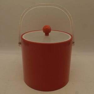 May include: A red plastic ice bucket with a clear plastic handle and a white lid with a red knob.
