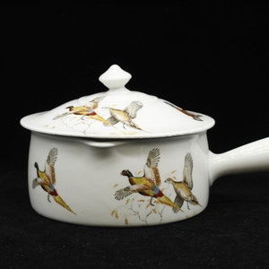 Puede incluir: Plato de cerámica blanca para hornear con tapa y asa. El plato está decorado con un patrón de faisanes volando.