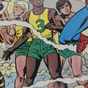 May include: Comic book panel featuring several figures in action. One figure wears a yellow tank top with a green number 3, green shorts, and is embraced by others. A superhero in blue and red is also present.