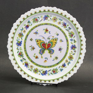 May include: White ceramic serving platter with a scalloped edge. The centre features a colourful butterfly design surrounded by floral patterns in blue, yellow, and red. A green border encircles the butterfly and flowers.