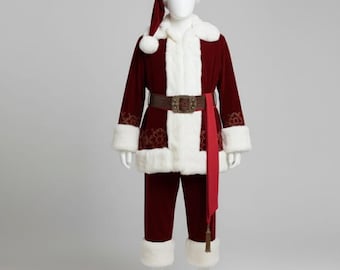 May include: A Santa Claus costume on a mannequin. The costume includes a burgundy jacket and pants with white faux fur trim, a matching hat, and a brown belt. A red sash hangs from the belt. The jacket has decorative patterns on the sleeves.