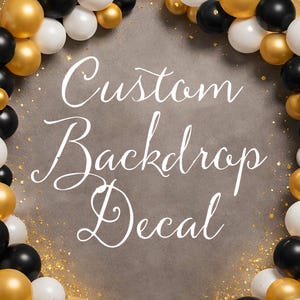 May include: A custom backdrop decal with the words "Custom Backdrop Decal" in white script. The backdrop is surrounded by a border of black, gold, and white balloons, with gold confetti accents.