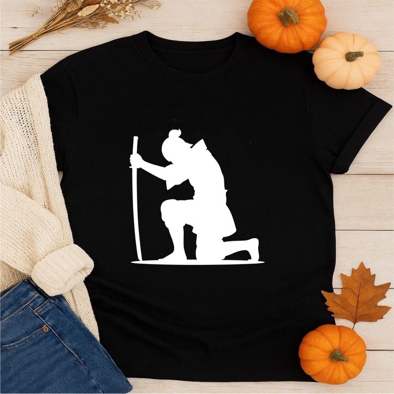 May include: Black t-shirt featuring a white silhouette of a kneeling samurai holding a sword. The design is a minimalist graphic, perfect for fans of Japanese culture and martial arts. The shirt is a classic crew neck.