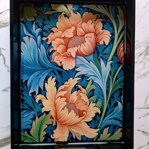 May include: A rectangular serving tray with a black frame and handles. The tray's surface features a floral design with large orange and yellow flowers, blue leaves, and green accents on a dark blue background.