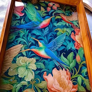 May include: Wooden serving tray with a vibrant hummingbird and floral design. The tray features a dark blue background with colorful birds and flowers in shades of blue, green, red, and peach. The tray has a natural wood frame.