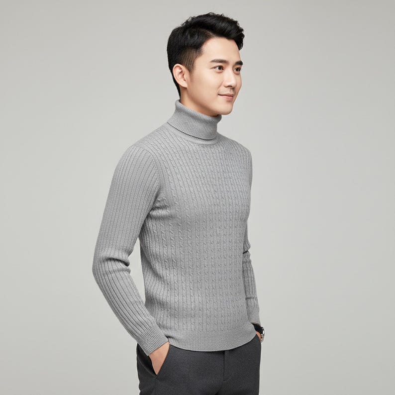 May include: A light gray turtleneck sweater with a cable knit design. The long-sleeved sweater has a ribbed texture on the sleeves and a classic, comfortable fit. The sweater is made of a soft, warm material.