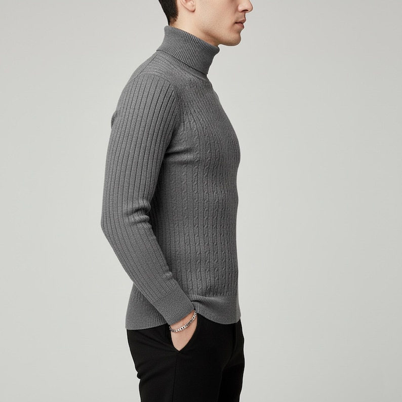May include: A gray turtleneck sweater with ribbed and cable knit detailing. The long-sleeved sweater is made of a soft material and is shown on a person wearing black pants.