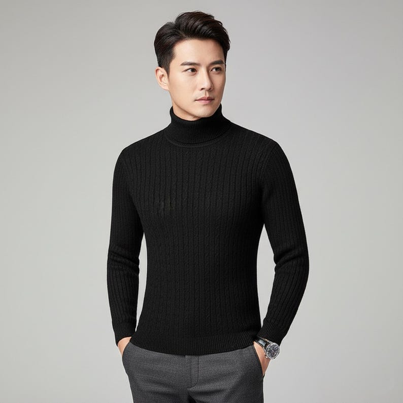 May include: A black turtleneck sweater with a ribbed texture. The long-sleeved sweater is made of a soft material and is suitable for cooler weather. The model is wearing gray pants and a watch.