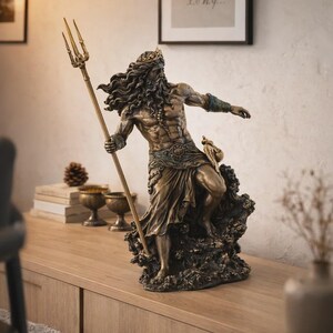 May include: Bronze-colored statue of a muscular male figure, possibly a deity, holding a trident. The statue has long, flowing hair and a beard, wearing a crown and draped fabric. It stands on a textured base, with intricate details and a classical aesthetic.