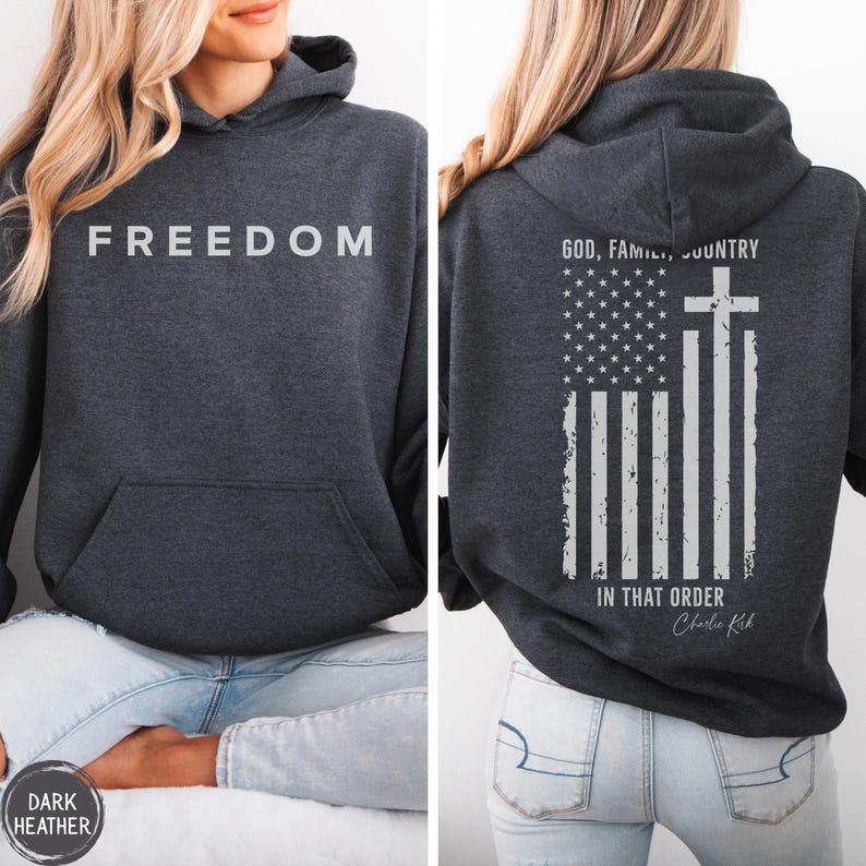 May include: Dark heather gray hoodie with the word "FREEDOM" printed across the chest. The back features an American flag design with a cross and the text "GOD, FAMILY, COUNTRY IN THAT ORDER".
