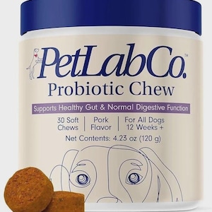 Puede incluir: Un envase blanco con tapa azul, etiquetado como "PetLabCo Probiotic Chew". El texto indica que el producto favorece la salud intestinal y la funci&oacute;n digestiva normal en perros. El envase contiene 120 g de golosinas. Se ven varias golosinas blandas.