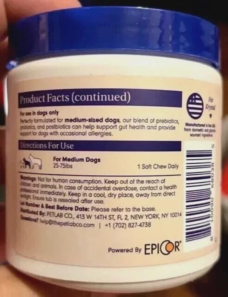 Puede incluir: Un envase de suplemento blanco y beige con tapa azul. La etiqueta incluye texto sobre el uso del producto para perros medianos, instrucciones y advertencias. El envase es solo para perros y contiene prebi&oacute;ticos y probi&oacute;ticos.