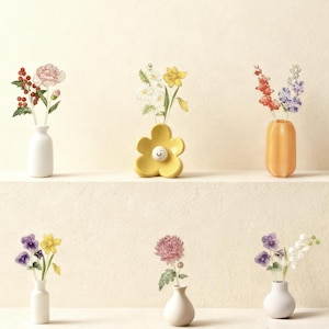 Könnte beinhalten: Eine Sammlung kleiner Vasen, jede mit einem anderen Blumenarrangement. Die Vasen haben verschiedene Formen und Farben, darunter Weiß, Gelb und Orange. Die Blumen umfassen rosa, rote, lila und gelbe Blüten und schaffen eine fröhliche und farbenfrohe Präsentation.