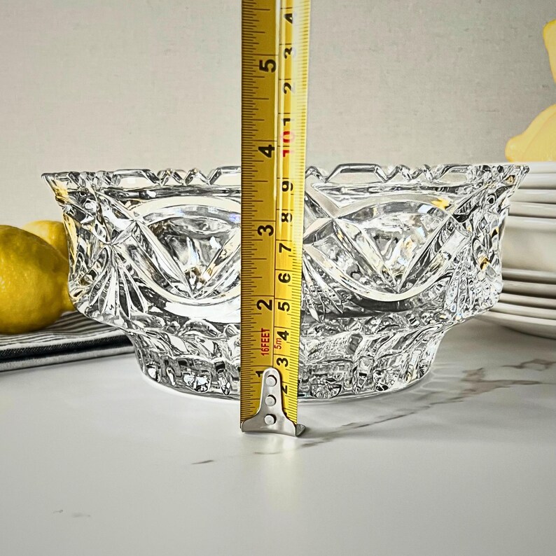Peut inclure: Un bol en verre taill&eacute; transparent avec un motif en losange. Le bol mesure environ 7,6 cm de haut. Le bol est sur une surface blanche. Des citrons et une pile d'assiettes blanches sont en arri&egrave;re-plan.