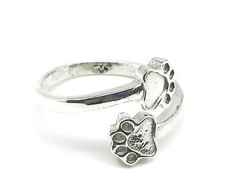 Elegante anillo ajustable de plata de ley 925 con doble huella de pata, ideal para amantes de los animales.