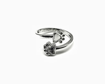 Elegante anillo ajustable de plata de ley 925 con doble huella de pata, ideal para amantes de los animales.