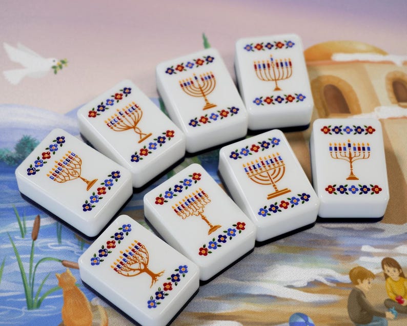 May include: A set of seven white rectangular tiles, each featuring a gold menorah illustration with blue and red candles, surrounded by a decorative border of small blue, red, and yellow flowers. The tiles have a smooth, glossy finish.