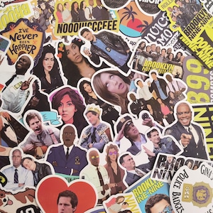 Peut inclure: Un assortiment d'autocollants colorés représentant les personnages et les logos de la série télévisée Brooklyn Nine-Nine. Les autocollants incluent des images des acteurs, le logo de l'émission et des phrases comme "I've Never Been Happier."