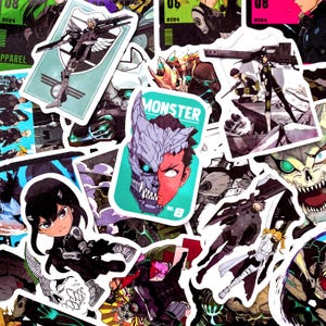 Pu&ograve; includere: Una collezione di adesivi in stile anime con vari personaggi e disegni. Gli adesivi presentano una gamma di colori, tra cui verde acqua, rosso e nero, con la parola "MONSTER" su un adesivo. Gli adesivi sono di varie dimensioni e forme.
