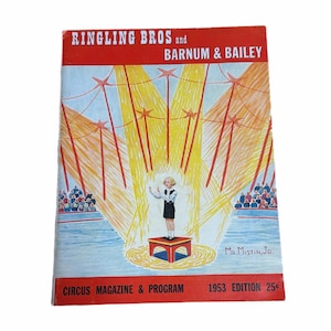 Peut inclure: Couverture de magazine de cirque Ringling Bros. et Barnum & Bailey vintage. La couverture présente un dessin d'un jeune artiste sur scène, avec des projecteurs et un public. Le magazine est de l'édition 1953.