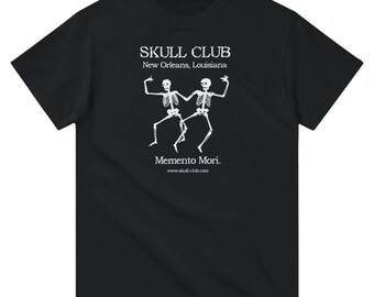 May include: Black t-shirt with a white graphic featuring two dancing skeletons. The text "SKULL CLUB New Orleans, Louisiana" is above the skeletons, with "Memento Mori." and a website address below.