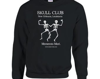 May include: Black sweatshirt with white text and graphic. The text reads "SKULL CLUB New Orleans, Louisiana" above a dancing skeleton graphic. Below the graphic is the text "Memento Mori." and the website address.