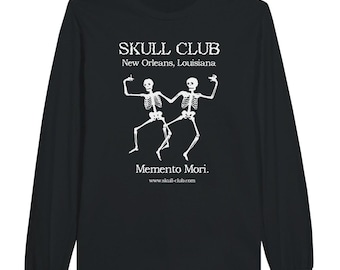May include: Black long-sleeve shirt with a white graphic. The graphic features two dancing skeletons with the text "SKULL CLUB New Orleans, Louisiana" above and "Memento Mori" below. The website address www.skull-club.com is also visible.