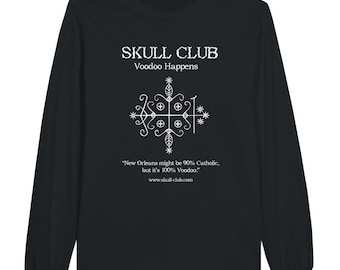 May include: Black long-sleeve shirt with white text and a graphic. The text reads "SKULL CLUB Voodoo Happens" above a symbol. Below the symbol is the text: "New Orleans might be 90% Catholic, but it's 100% Voodoo." and www.skull-club.com.